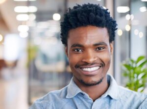 Creative, black man and smile with portrait in office of design agency for work in graphic designer and professional. Male employee, worker and pride for career, space and confident in workspace.